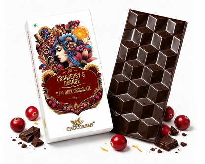 A bar of chocolate and its packaging box on a white background. The box is white with a colorful illustration of a woman surrounded by cranberries and citrus, labeled 'Cranberry & Orange 5th Dark Chocolate'.